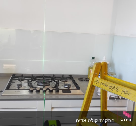 סולם צהוב, קו לייזר ירוק, כיריים במטבח